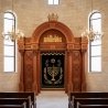 Exquisite hand-carved Aron Kodesh with embroidered velvet parochet, a testament to premium synagogue furniture manufacturing.