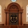 Majestic hand-carved Aron Kodesh with gold-embroidered velvet parochet, a masterpiece of synagogue furniture craftsmanship.